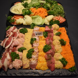 Fondueschotel van Keurslager Miguel met gepaneerde balletjes, spekrolletjes, brochettes en vlees in blokjes, met een schotel verse groentjes