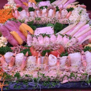 Koude vlees- en visschotel met hamrolletjes, garnalen, gamba's, asperges en meloen