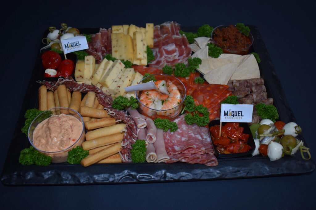 Tapasschotel van Keurslager Miguel met kaas, salami, rauwe ham, grissini, scampi, olijven en dipsausjes